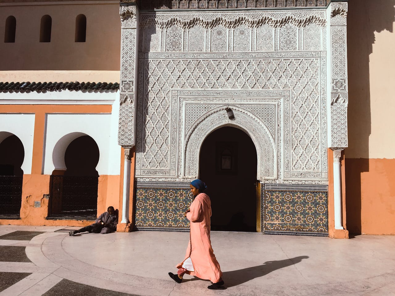 Person Walking Beside Mosque